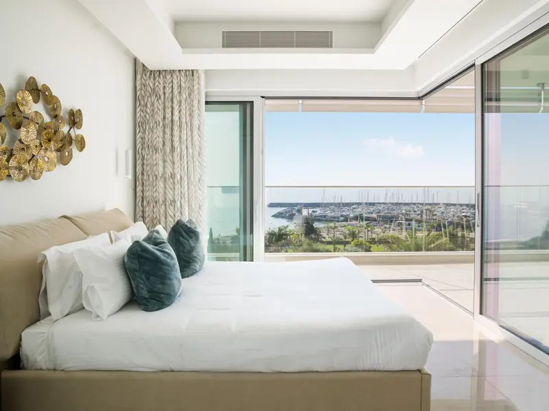 Une chambre lumineuse avec un grand lit donnant sur une vue mer.