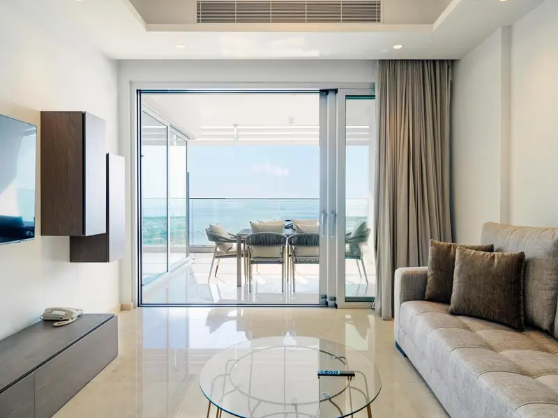 Un salon lumineux s'ouvre sur une terrasse avec vue sur la mer.