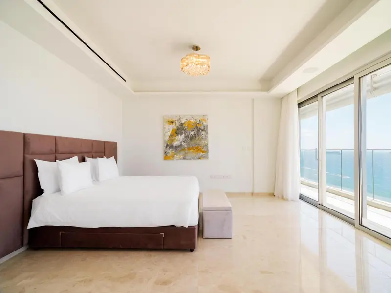 Une chambre lumineuse avec un grand lit et une vue sur la mer.