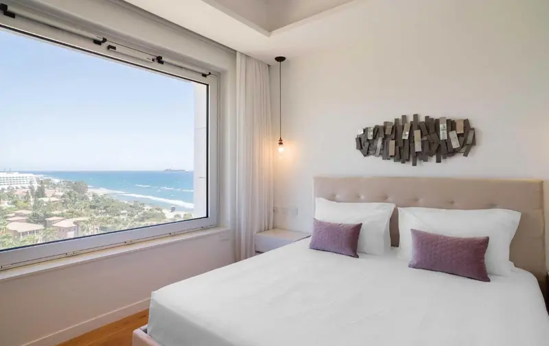 Une chambre lumineuse avec un grand lit et une vue sur la mer.