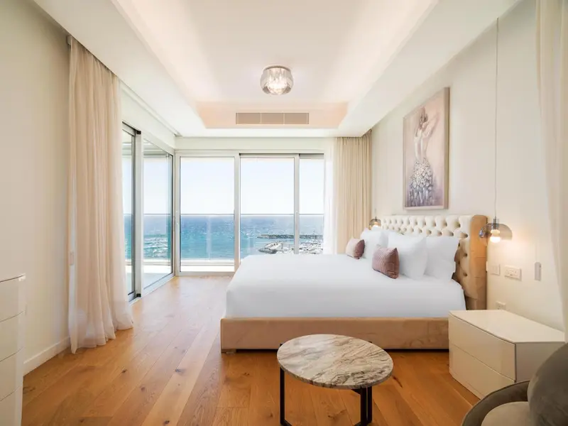 Une chambre lumineuse avec un grand lit et une vue sur la mer.