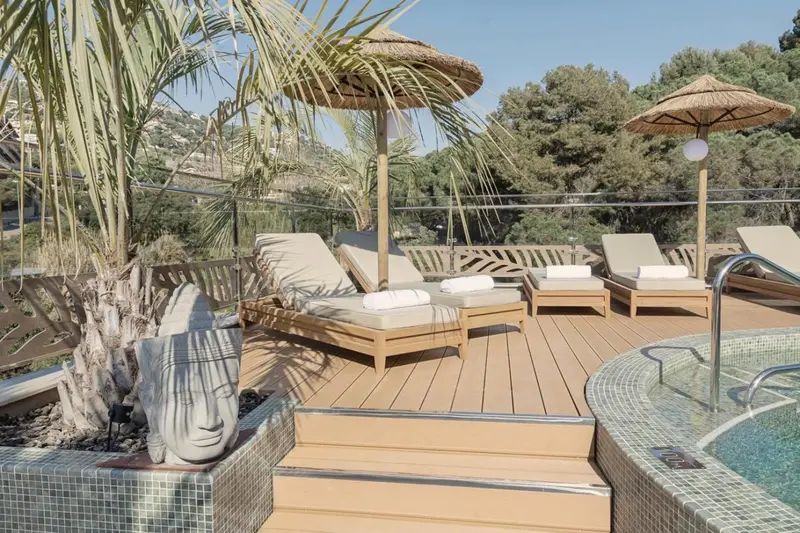 Terrasse aménagée avec transats et parasols près d'une piscine.