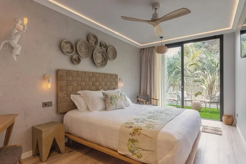 Une chambre lumineuse avec un grand lit et un accès à une terrasse.