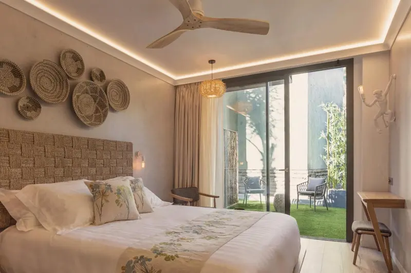 Une chambre lumineuse avec un grand lit et un accès à une terrasse.