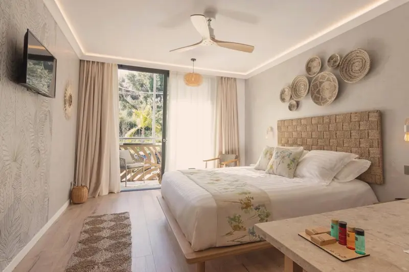 Une chambre lumineuse avec un grand lit et un accès à une terrasse.