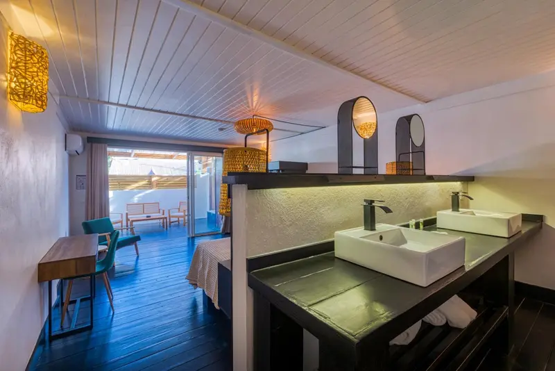 Une chambre moderne avec salle de bain ouverte sur l'espace nuit et accès à une terrasse.