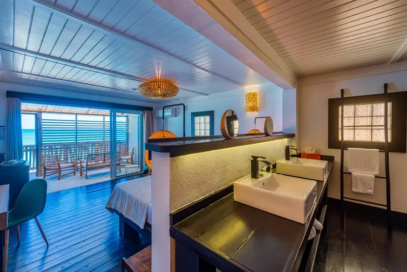 Une chambre lumineuse s'ouvre sur une terrasse avec vue sur la mer.