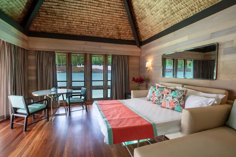 Une chambre lumineuse avec un lit et un coin repas.