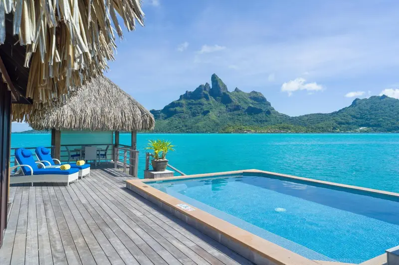 Terrasse en bois avec piscine et vue sur l'océan et les montagnes.