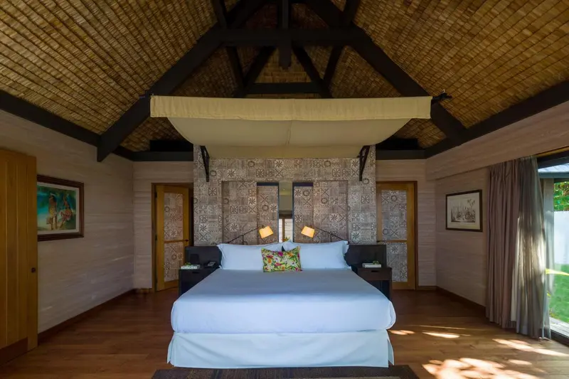 Une chambre lumineuse avec un grand lit à baldaquin et une décoration soignée.