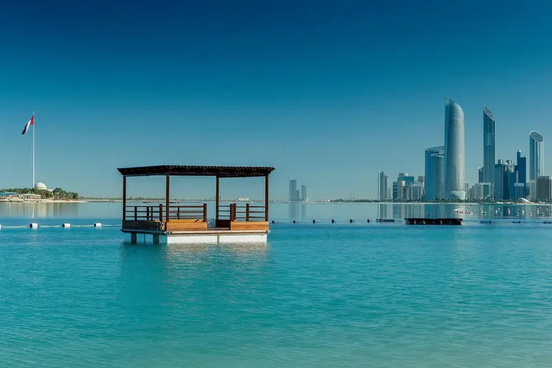 Plateforme en bois sur l'eau avec un abri et une vue sur la ville.