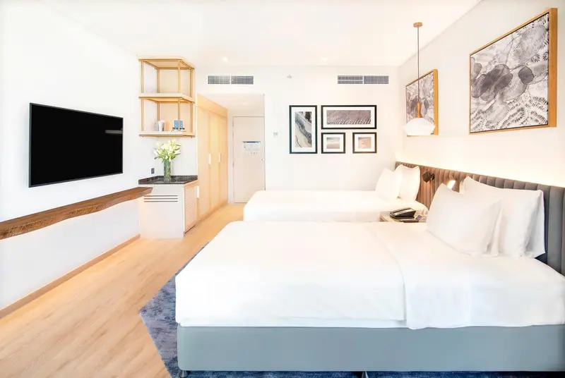 Une chambre lumineuse avec deux lits simples et une décoration moderne.