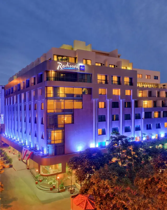 Bâtiment moderne illuminé de couleurs vives au crépuscule.