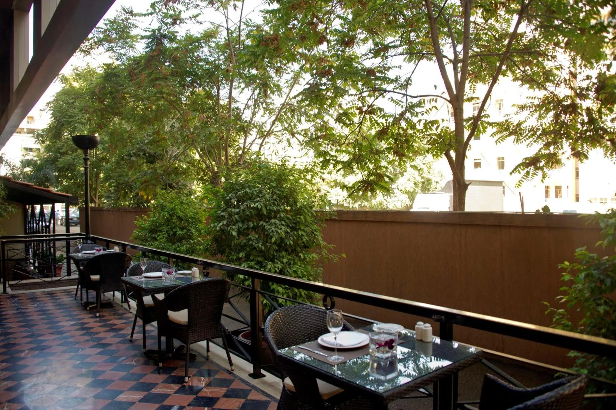 Tables dressées sur une terrasse ombragée avec vue sur la végétation.