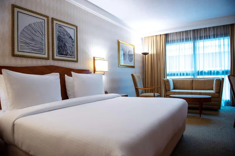 Une chambre lumineuse avec un grand lit et un coin salon.
