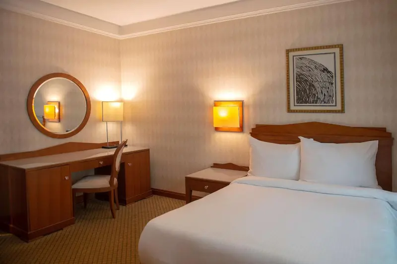 Une chambre d'hôtel lumineuse avec un bureau et un lit.