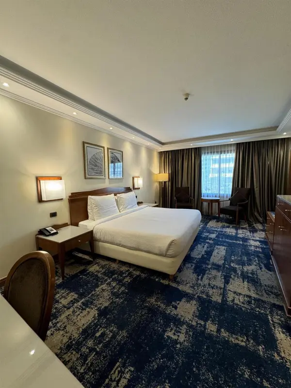 Une chambre d'hôtel lumineuse avec un grand lit et un coin salon.