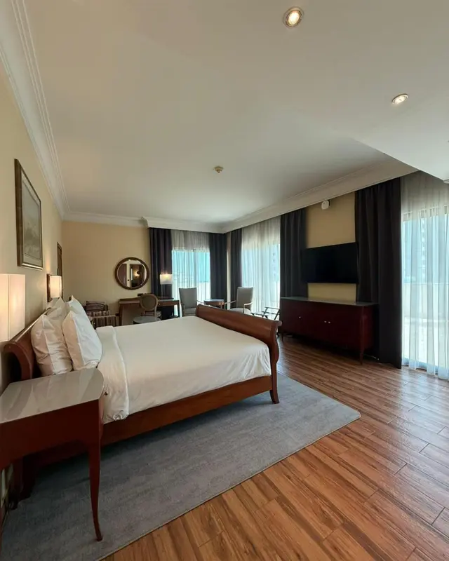 Une chambre spacieuse avec un grand lit et un coin salon.