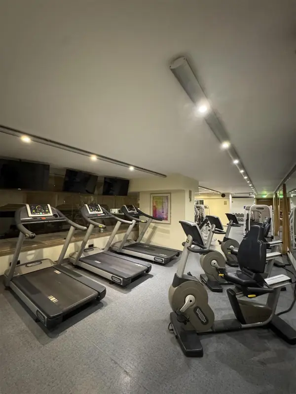 Une salle de sport lumineuse avec plusieurs appareils de cardio.