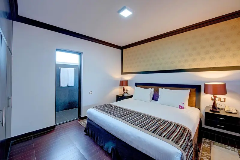 Une chambre lumineuse avec un grand lit et une décoration sobre.