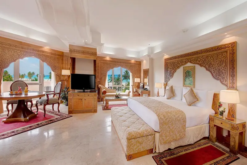 Une chambre spacieuse et lumineuse avec un grand lit et un coin repas.