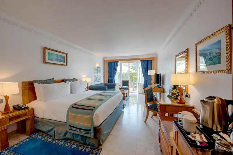 Une chambre lumineuse avec un grand lit et un coin salon.