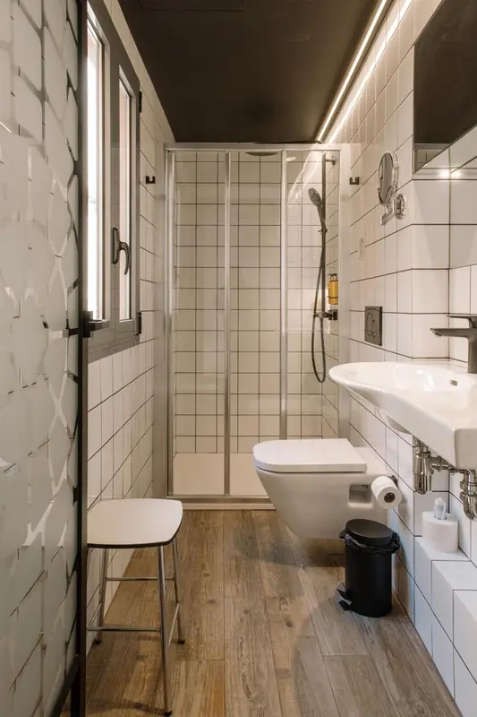 Une salle de bain moderne avec douche à l'italienne et carrelage blanc.