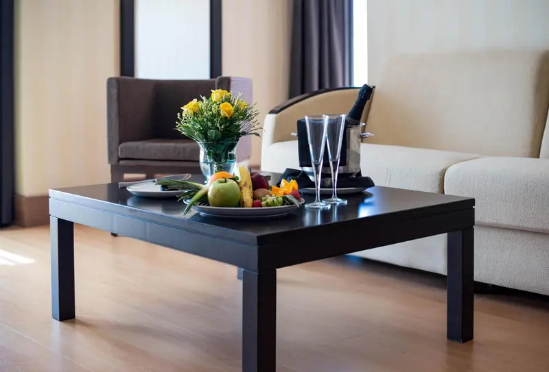 Une table basse avec une composition florale et des fruits frais dans un intérieur clair.