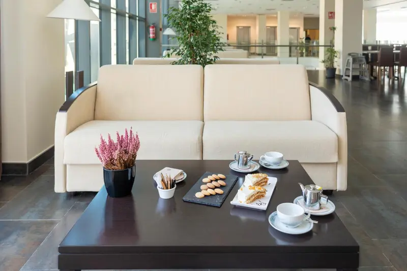 Un salon d'attente avec canapés, une table basse et une petite collation.