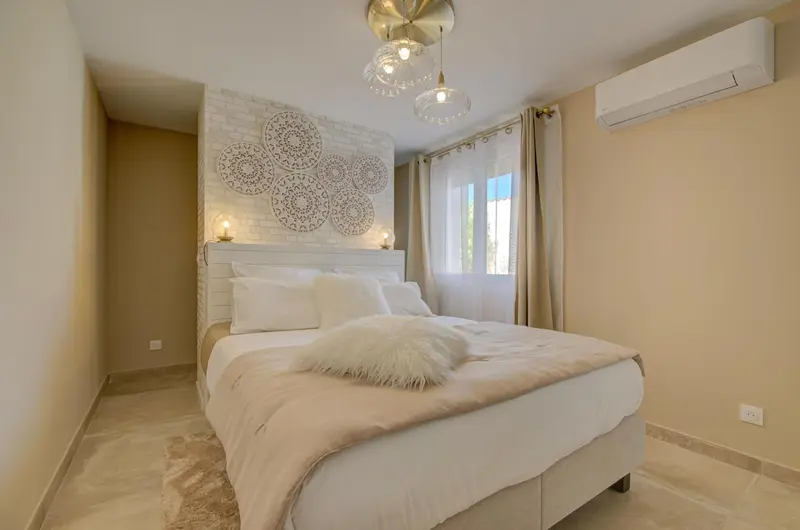 Une chambre lumineuse avec un grand lit recouvert d'une courtepointe moelleuse.