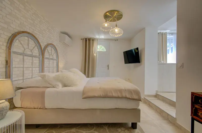 Une chambre lumineuse avec un grand lit et des fenêtres en arc.