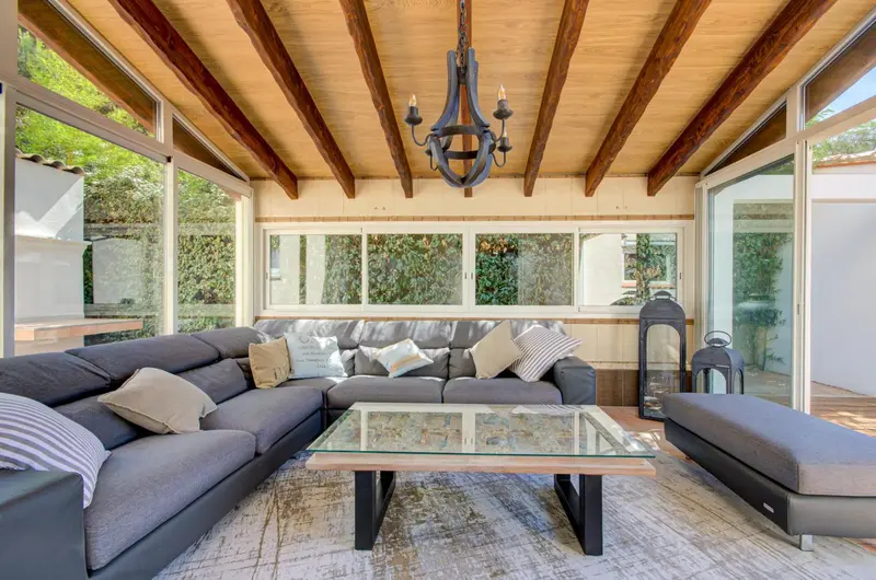 Espace de détente intérieur avec canapés et table basse sous un plafond en bois.