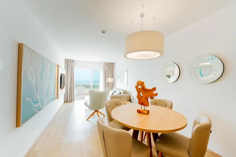 Espace de vie lumineux avec coin repas et vue sur la mer.