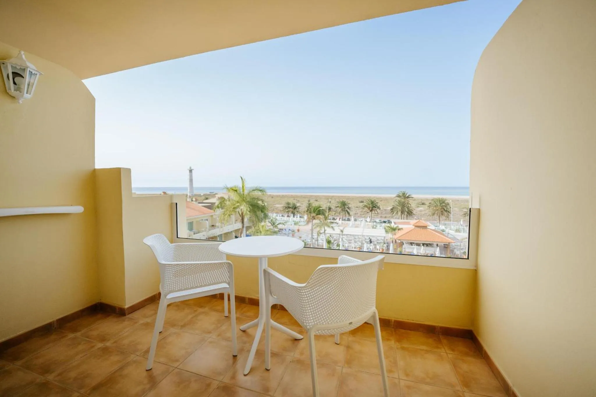 Terrasse avec mobilier blanc donnant sur une vue mer dégagée.