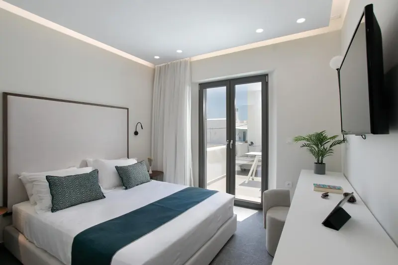 Une chambre lumineuse avec un lit double et un accès à une terrasse.
