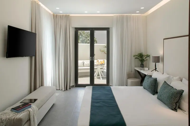 Une chambre lumineuse avec un lit et un accès à une terrasse.