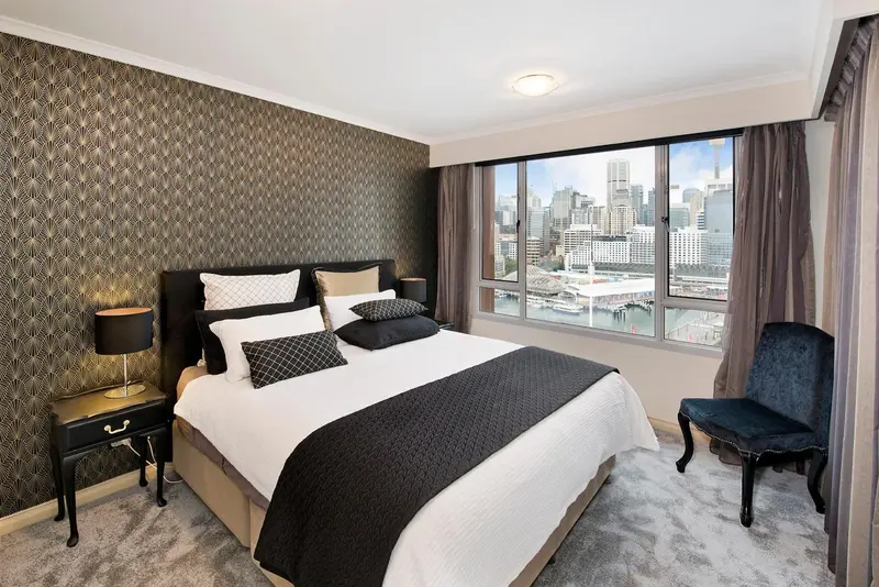 Une chambre moderne avec un grand lit et une vue sur la ville.