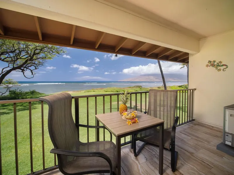 Terrasse avec mobilier et vue sur la mer.