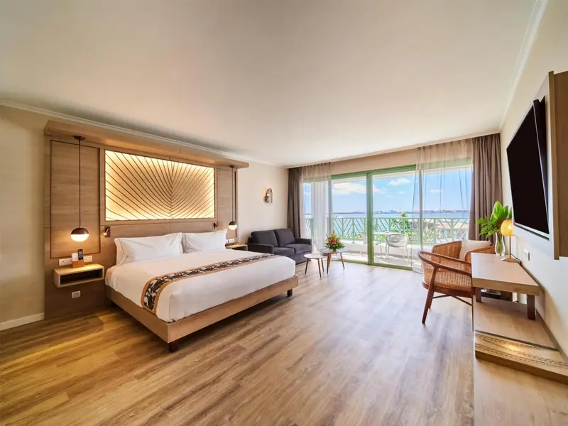 Une chambre lumineuse avec un grand lit et un accès à une terrasse.