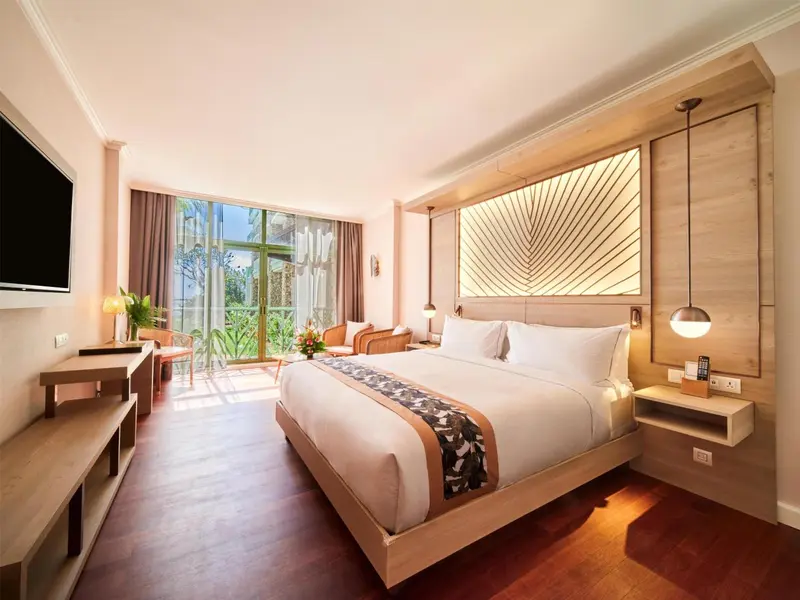 Une chambre lumineuse avec un grand lit et un accès à une terrasse.