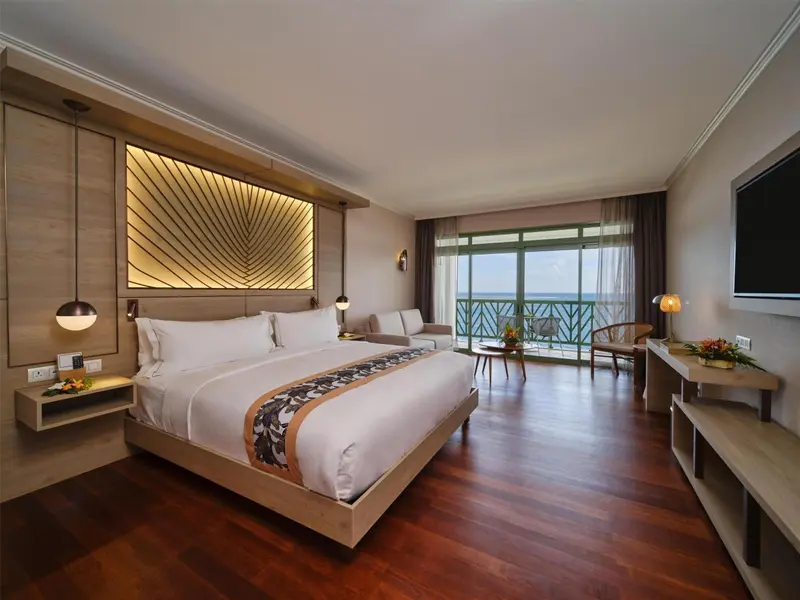Une chambre spacieuse avec un grand lit et un balcon donnant sur la mer.