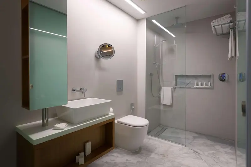 Une salle de bain moderne avec douche à l'italienne et lavabo intégré.