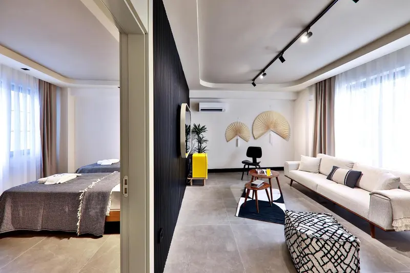 Espace de vie lumineux avec canapé, table basse et lit fait.