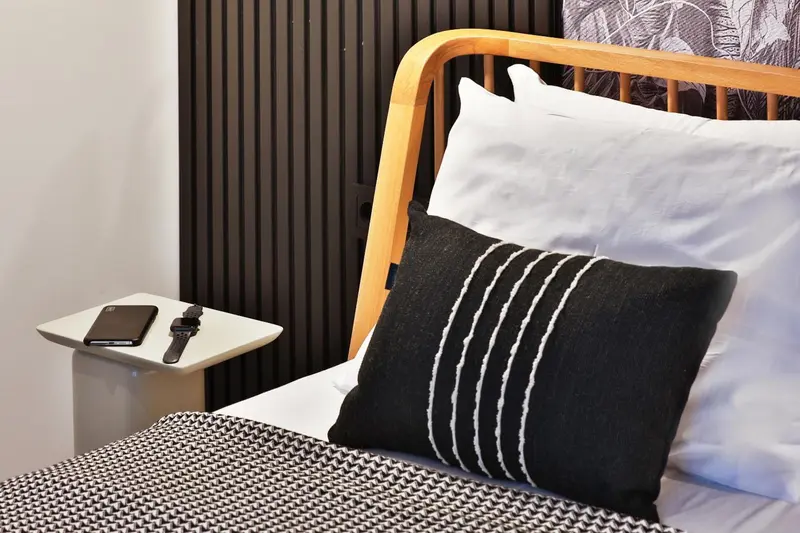 Un lit avec oreillers et couverture décorative dans une chambre.