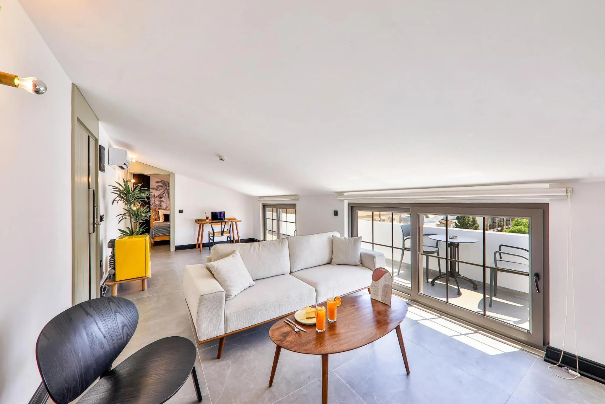 Espace de détente lumineux avec canapé et accès à une terrasse.