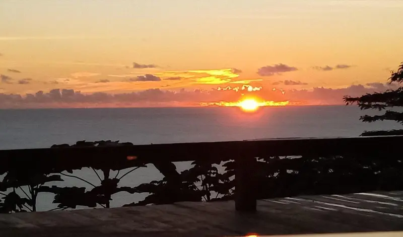 Le soleil se couche sur l'océan depuis une terrasse.