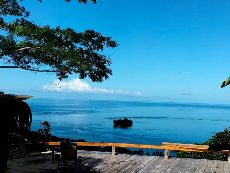 Vue panoramique sur l'océan depuis une terrasse en bois.