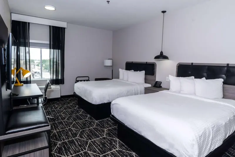 Chambre d'hôtel avec deux lits doubles et une décoration moderne.