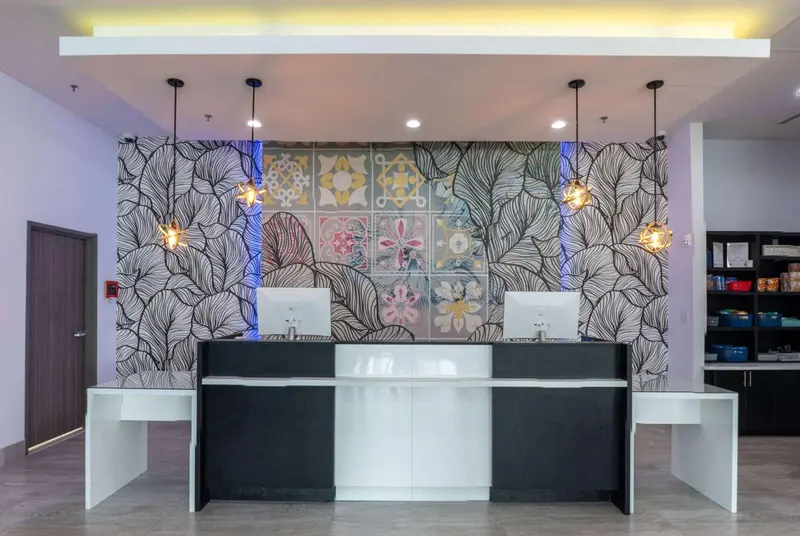 Un comptoir d'accueil moderne avec un mur décoratif.