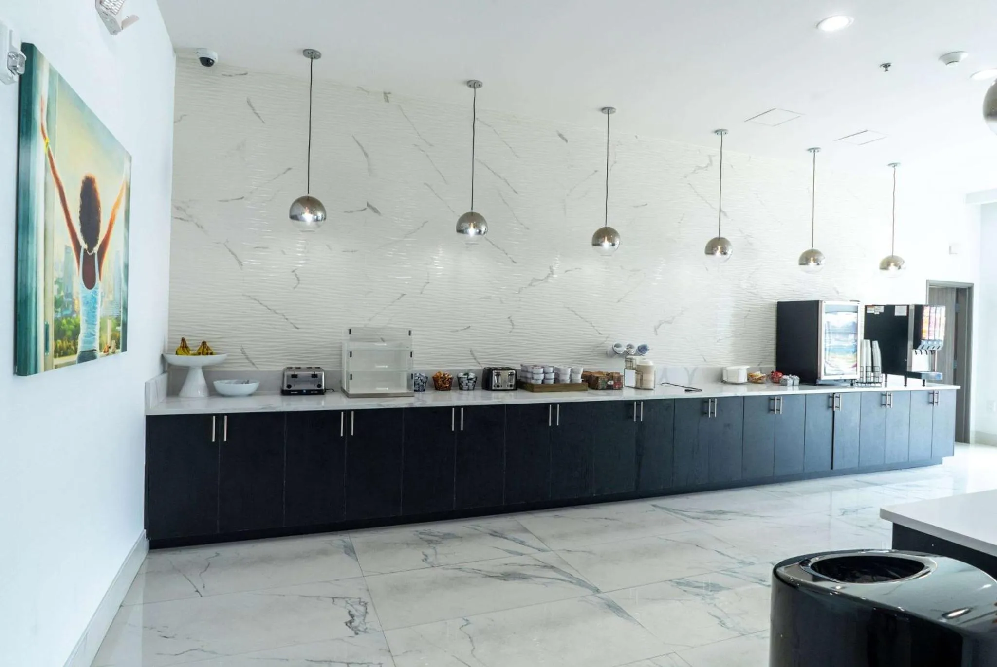 Un long comptoir sombre présente une sélection de nourriture et de boissons dans une salle lumineuse.